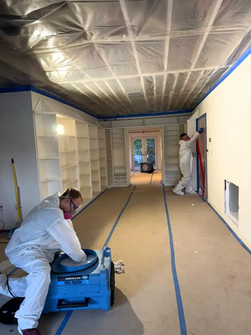 24/7 Service Pros technician inspecting water damage during a restoration job